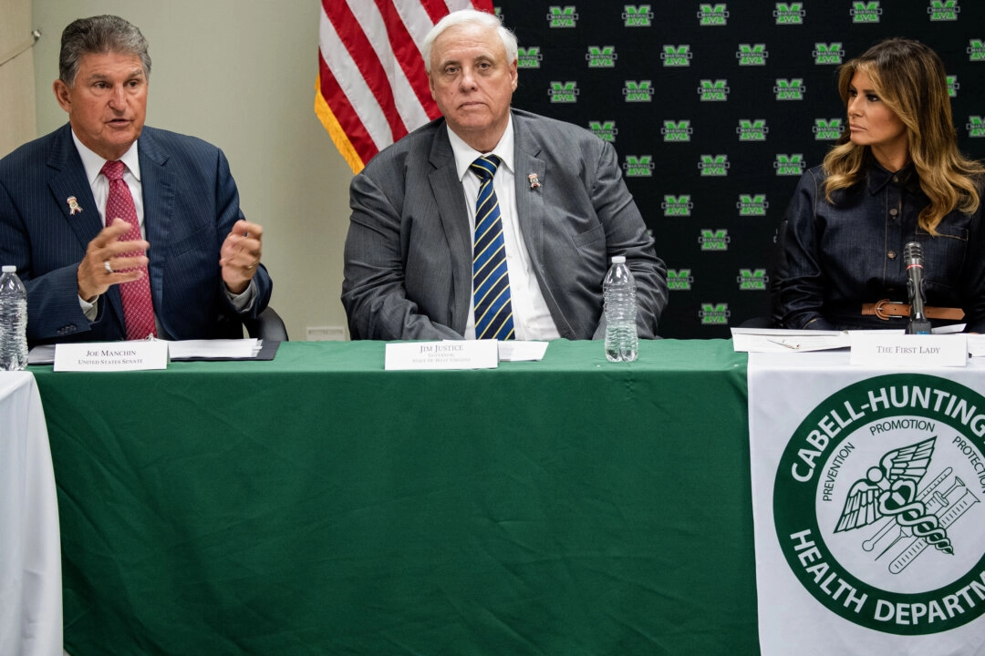 <em>La primera dama de Estados Unidos, Melania Trump (derecha), el gobernador de Virginia Occidental, Jim Justice (centro), y el senador estadounidense Joe Manchin (izquierda), demócrata de Virginia Occidental, asiste a una mesa redonda sobre la epidemia de opioides con funcionarios locales y estatales en el Departamento de Salud de Cabell-Huntington en Huntington, Virginia Occidental, el 8 de julio de 2019. (Foto de SAUL LOEB/AFP vía Getty Images)</em>