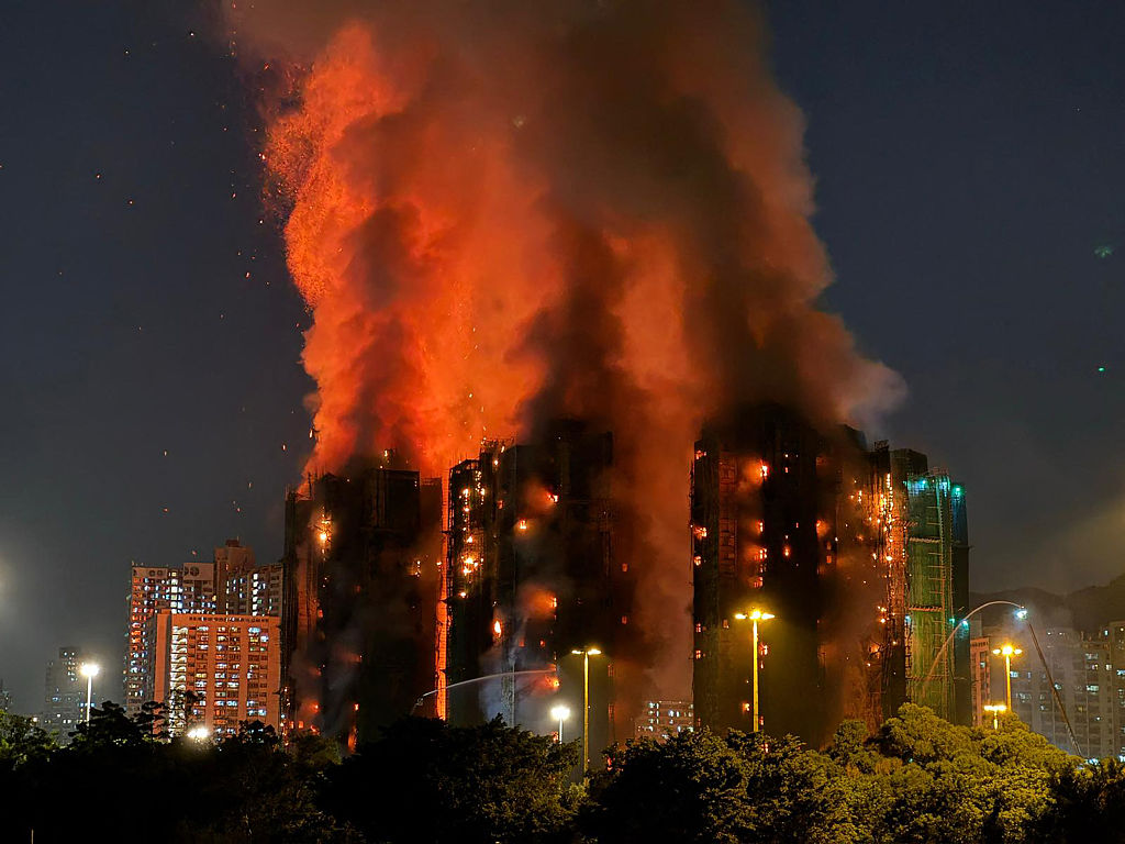 Una densa columna de humo y llamas se elevan mientras un gran incendio envuelve varios bloques de apartamentos en Wang Fuk Court, distrito Tai Po de Hong Kong, el 26 de noviembre de 2025. Al menos cuatro personas murieron cuando un incendio arrasó varios bloques de apartamentos en Hong Kong el 26 de noviembre, según informó el gobierno. Los medios dijeron que algunos residentes quedaron atrapados en el interior. (Foto de Yan ZHAO / AFP vía Getty Images)