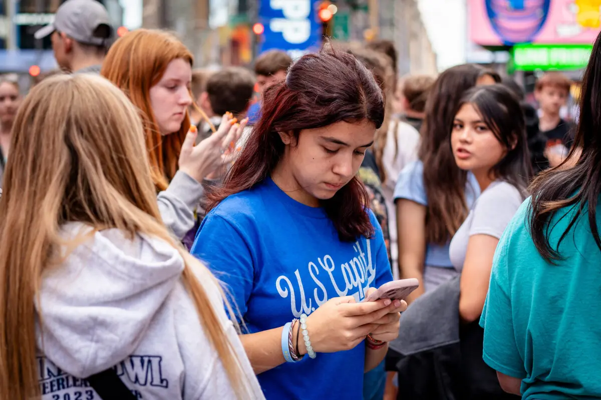 Una joven utiliza un teléfono móvil en la ciudad de Nueva York el 10 de junio de 2024. Los expertos advierten que las redes sociales están distorsionando la visión que los jóvenes tienen del mundo. (Samira Bouaou/The Epoch Times).