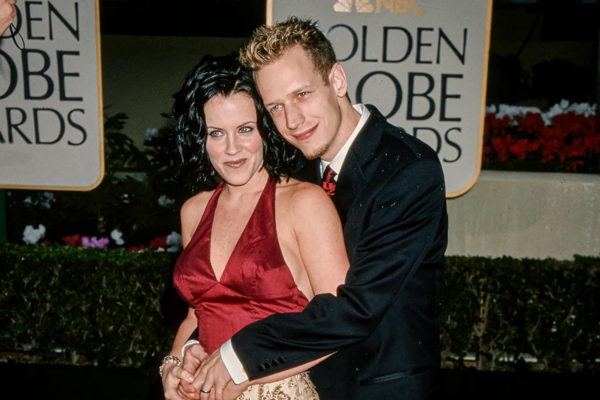 Jenny McCarthy es abrazada por su marido, el actor John Asher, en la 57.ª edición de los Globos de Oro en Beverly Hills, California, el 23 de enero de 2000. McCarthy, de 53 años, se convirtió en un nombre muy conocido en 2005 después de compartir la historia del diagnóstico de autismo de su hijo Evan tras recibir la vacuna triple viral. (Vinnie Zuffante/Getty Images)