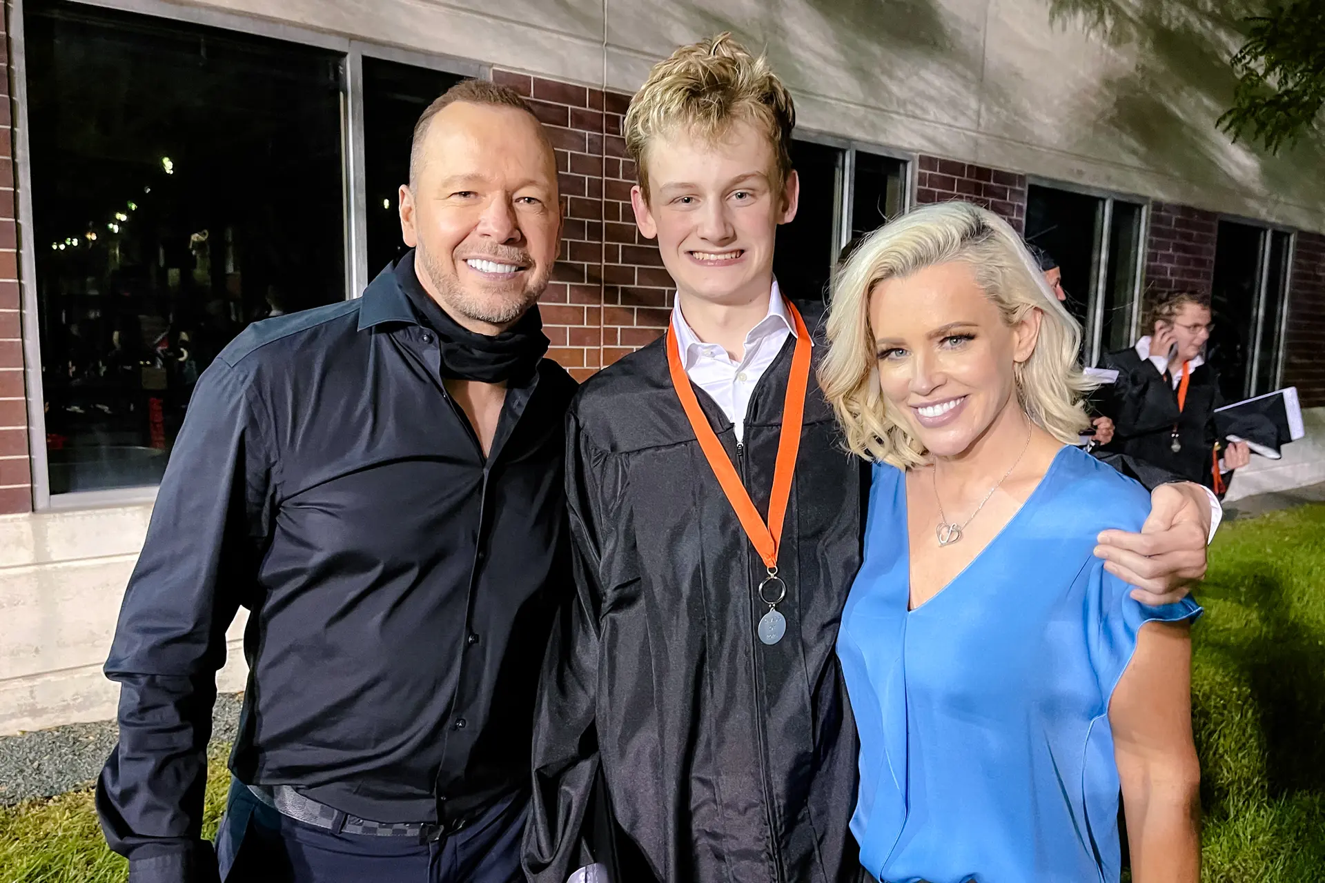 Jenny McCarthy (derecha) en la graduación de secundaria de su hijo Evan con su marido, Donnie Wahlberg, en una foto sin fecha. McCarthy dice que la condición de Evan mejoró después de descubrir Generation Rescue, una organización sin ánimo de lucro que promueve un protocolo para ayudar a los niños autistas. (Cortesía de Jenny McCarthy Productions)