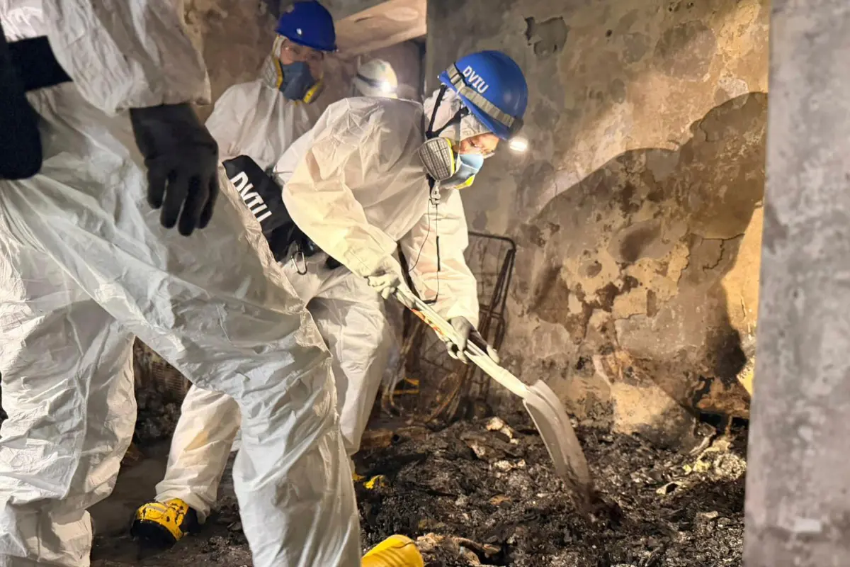 <em>Miembros de la Unidad de Identificación de Víctimas de Desastres trabajan en un apartamento tras el incendio mortal del miércoles en Wang Fuk Court, una urbanización en el distrito de Tai Po (Nuevos Territorios), Hong Kong, el 30 de noviembre de 2025. (División de Relaciones Públicas de la Policía de Hong Kong vía AP)</em>