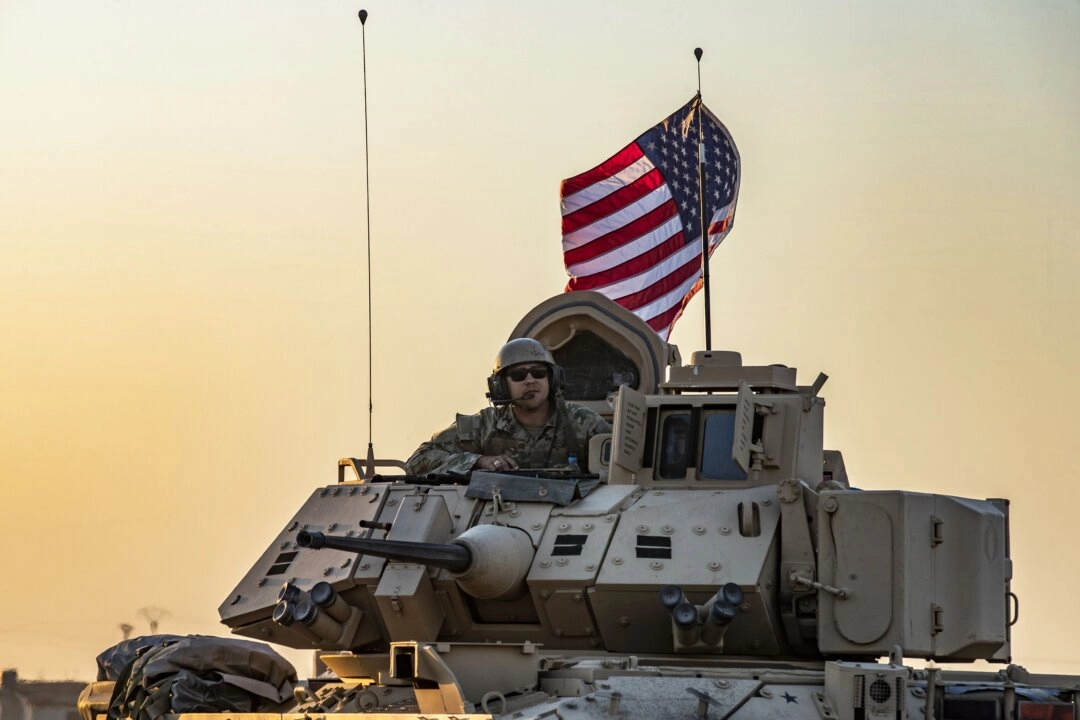 <em>Un soldado estadounidense se sienta a bordo de un vehículo blindado de transporte de personal Bradley mientras este se desplaza cerca de la ciudad de Tal Tamr, en la provincia de Hasakeh, al noreste de Siria, en la frontera con Turquía, el 10 de noviembre de 2019. (Delil Souleiman/AFP vía Getty Images)</em>