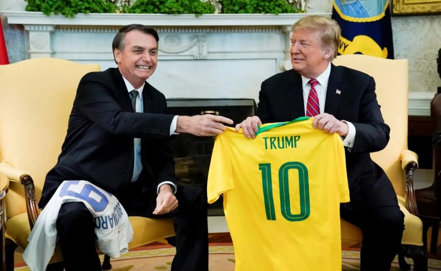 El presidente brasileño, Jair Bolsonaro, entrega una camiseta de la selección brasileña de fútbol al presidente estadounidense, Donald Trump, durante una reunión en el Despacho Oval de la Casa Blanca, el 19 de marzo de 2019. (Kevin Lamarque/Reuters)