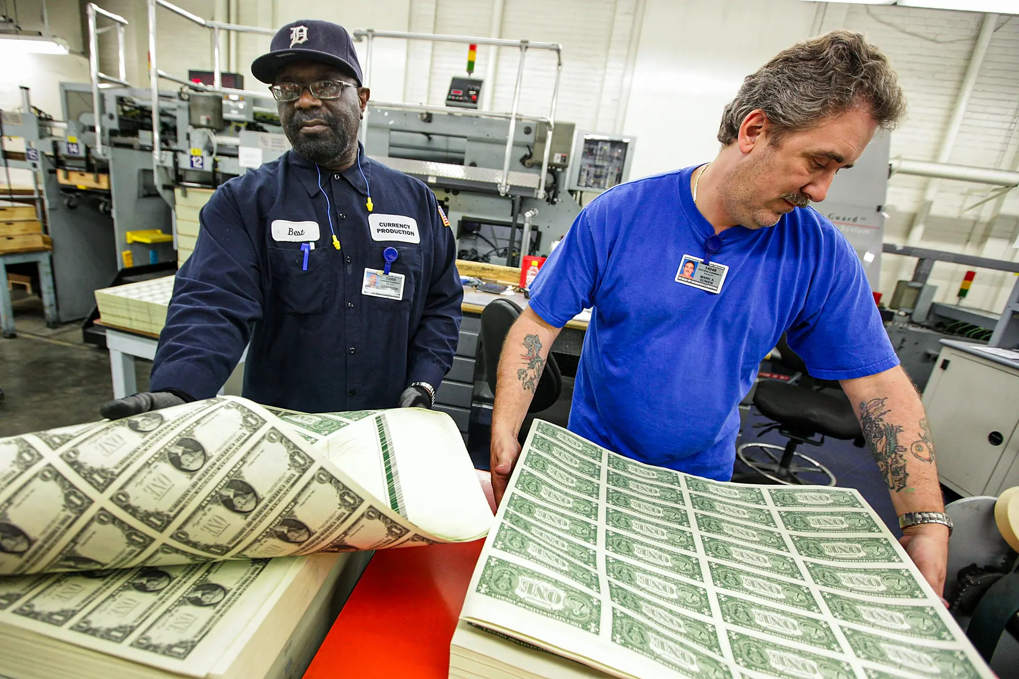 Unos trabajadores sueltan una pila de billetes de 1 dólar en una mesa vibratoria antes de cortarlos en billetes de 1 dólar en la Oficina de Grabado e Impresión de Washington el 26 de marzo de 2009. (Mark Wilson/Getty Images)