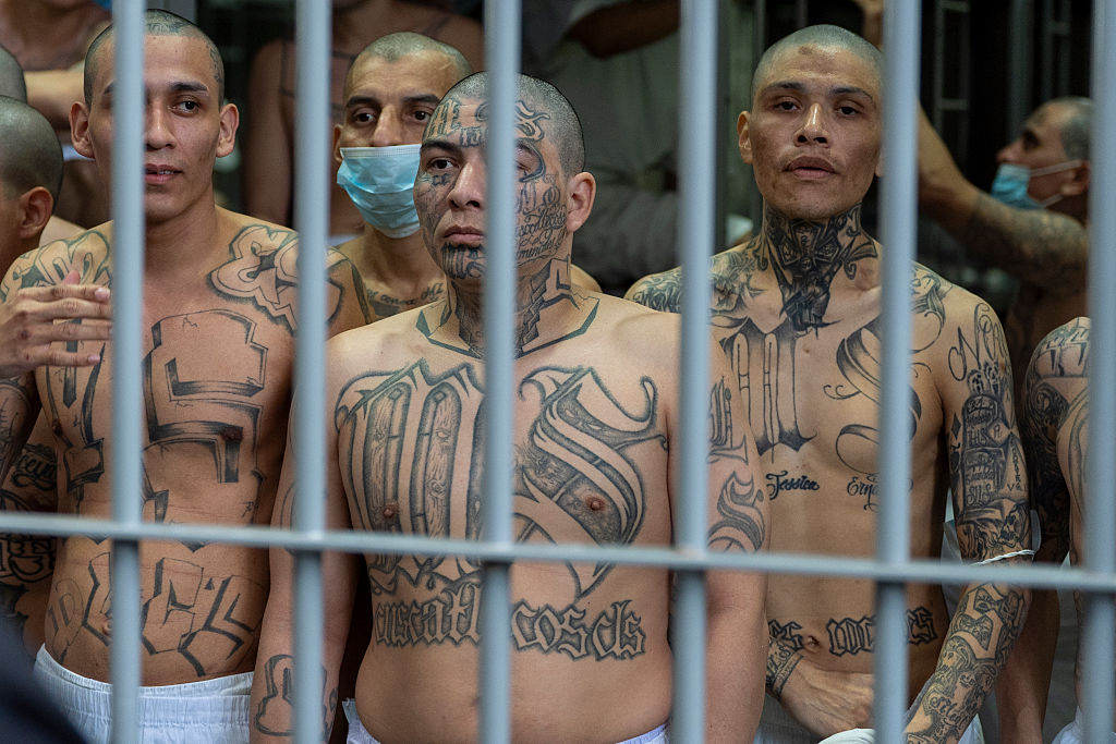 Un preso con tatuajes de la pandilla MS-13 mira desde su celda mientras la secretaria del Departamento de Seguridad Nacional, Kristi Noem, visita el Centro de Confinamiento de Terroristas (CECOT) el 26 de marzo de 2025 en Tecoluca, El Salvador. (Alex Brandon-Pool/Getty Images)